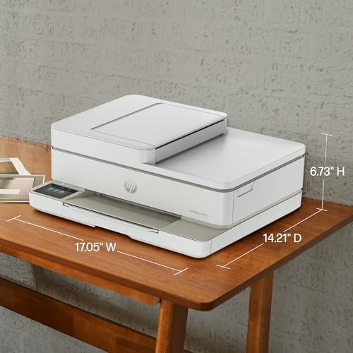 Modern printer on a wooden desk with dimensions labeled.