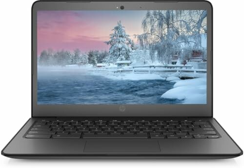 Laptop displaying a snowy winter landscape on screen